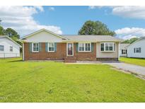 Charming brick home featuring a well-manicured lawn and traditional design elements at 102 Pine St, Dunn, NC 28334