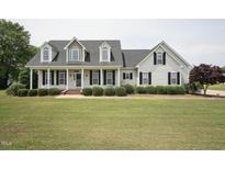 Charming two-story home with a welcoming front porch, manicured lawn, and classic black shutters at 105 Bagley Ln, Dunn, NC 28334