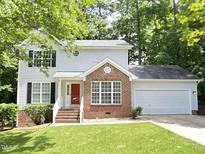 Charming two-story home with a red brick facade, complemented by a lush green lawn and an attached two-car garage at 109 Elmview Dr, Cary, NC 27519