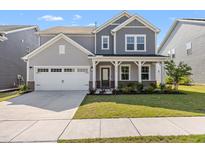 Charming two-story home with a well-manicured lawn, white garage door, and covered front porch at 1165 Sun Spgs Rd, Wake Forest, NC 27587