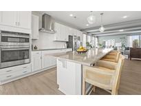 Modern kitchen featuring white cabinets, stainless steel appliances, and a large center island with bar seating at 1247 Shaw View Alley # 201, Raleigh, NC 27601