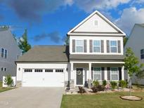 Traditional two-story home featuring a two car garage, manicured lawn and stone accents at 1311 Arena Ln, Fuquay Varina, NC 27526