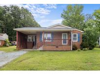 Charming one-story brick home with a cozy front porch and well-maintained lawn at 1416 Chestnut St, Roxboro, NC 27573