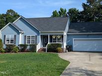 Charming home featuring a well-manicured lawn, attached garage, and delightful front porch at 154 Hillsdale Dr, Archer Lodge, NC 27527