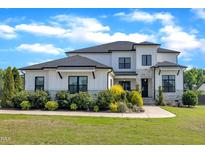 Stunning two-story home featuring a modern design with stone accents and manicured landscaping at 2004 Yamacraw Dr, Knightdale, NC 27545