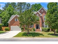 Beautiful brick home featuring manicured landscaping, attached garage, and a traditional design at 203 Worsham Dr., Chapel Hill, NC 27516