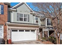 Charming townhome with a two-car garage, brick accents, and light blue siding at 2082 Weston Green Loop Loop, Cary, NC 27513