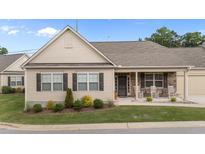 Charming single-story home featuring manicured lawn and inviting front porch with stone accents and comfortable seating at 24 W Catalina Ct, Clayton, NC 27527
