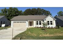 Charming one-story home featuring a two-car garage and a well-manicured lawn and concrete driveway at 245 Eason Creek Way, Clayton, NC 27527