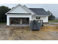 New construction home featuring white siding, dark roof, attached garage, and construction dumpster at 2760 Rains Mill Rd, Princeton, NC 27569