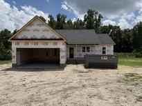 Exterior view of new home construction featuring attached garage and dumpster at 2776 Rains Mill Rd, Princeton, NC 27569