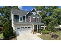 Charming two-story home showcasing a manicured lawn, attached garage, and inviting front porch at 2855 Wilkes Lake Dr, Fuquay Varina, NC 27526