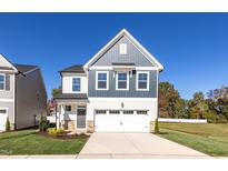Charming two-story home with landscaped yard and attached two-car garage at 293 Gregory Village Dr, Lillington, NC 27546