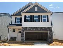 Charming two-story home featuring stone accents and a spacious two-car garage at 293 Gregory Village Dr, Lillington, NC 27546