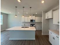 Modern kitchen boasts an island, sleek countertops, and stainless steel appliances at 293 Gregory Village Dr, Lillington, NC 27546