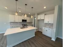 Spacious kitchen features a large island, stainless steel appliances, and ample white cabinetry at 293 Gregory Village Dr, Lillington, NC 27546