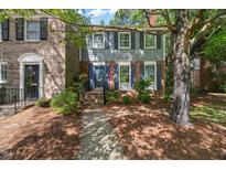 Charming two-story townhouse featuring blue shutters and an American flag at 3025 Wycliff Rd, Raleigh, NC 27607
