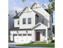 Charming two-story home features white siding, black roof, an attached two car garage and a welcoming red front door at 338 Beacon Dr, Pittsboro, NC 27312