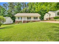Charming single-story home with a welcoming front porch and lush green lawn at 404 Southerby Dr, Garner, NC 27529