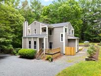 Attractive multi-story home featuring a wood-lined exterior, complemented by lush greenery at 406 Johns Woods Rd, Chapel Hill, NC 27516