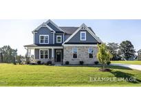 Charming two-story home featuring blue siding, brick accents, and a well-manicured lawn at 422 Grading Stick Ct, Angier, NC 27501
