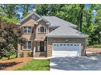 Charming brick home featuring a well-manicured lawn, attached garage, and inviting entrance at 5121 Ten Point Trl, Wake Forest, NC 27587