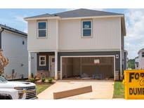 Two-story home with a spacious two-car garage and grey and white siding and well manicured lawn at 832 Ottawa Dr, Garner, NC 27529