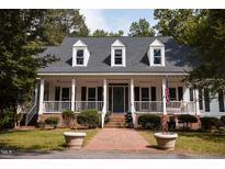 Charming home with a large porch, white columns and black shutters at 9200 Lake Carol Dr, Zebulon, NC 27597