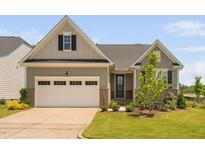 Charming home with attached garage, manicured lawn, and a well-maintained landscaped yard at 1002 Gilly Ct, Durham, NC 27703