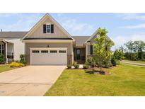 Charming single-Gathering home featuring a two-car garage, neutral siding, and professionally landscaped front yard at 1002 Gilly Ct, Durham, NC 27703