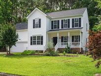 Charming two-story home with a well-maintained lawn and inviting front porch at 1010 Starita Ct, Apex, NC 27502