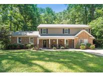 Charming two-story home with stone and siding, a covered porch, and a large manicured front yard at 1015 Manchester Dr, Cary, NC 27511