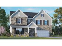 Charming two-story home featuring stone and vinyl siding, a covered porch, and a two-car garage at 121 Gilmer St, Fuquay Varina, NC 27526