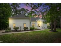 Charming white brick home with manicured landscaping and walkway to the front door at 12301 Hardee Rd, Raleigh, NC 27614