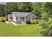 Charming single-story home with gray siding, well-manicured lawn, and mature landscaping at 133 Creekstone Dr, Benson, NC 27504