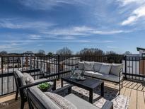 Relaxing outdoor deck featuring comfortable seating, a coffee table, and a beautiful view of the surrounding neighborhood at 1408 Sawyer Rd # 103, Raleigh, NC 27610