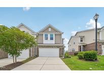 Charming two-story townhouse with a brick facade, white garage door, and well-maintained lawn and landscaping at 1534 Glenwater Dr, Cary, NC 27519