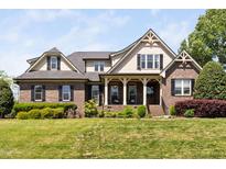 Charming brick two-story home featuring a manicured lawn and covered front porch at 154 Sicily Dr, Clayton, NC 27527