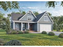 Charming blue two-story home featuring a well-manicured lawn, covered porch, and attached garage, inviting and picturesque at 161 Wheeler Ct, Clayton, NC 27527