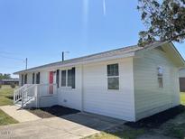 Charming single-story home featuring a bright red front door, white siding, black shutters, and well-manicured landscaping at 1676 Richardson Bass Rd, Kenly, NC 27542