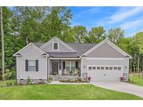 Charming home featuring stone accents, a well-manicured lawn, and an attached two-car garage at 176 Lowery Ln, Benson, NC 27504