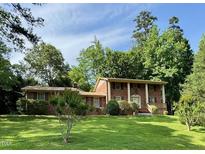 Traditional brick home with well-manicured lawn and mature trees at 1818 Brookrun Rd, Henderson, NC 27536