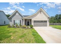 Charming one-story home with a manicured lawn, two-car garage, and brick and vinyl siding at 1828 Wellspring Ct, Graham, NC 27253