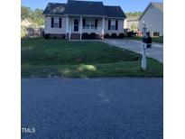 Quaint one-story home featuring a cozy front porch and a tidy front yard with a mailbox at 2001 Ballston Pl, Knightdale, NC 27545