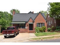 Charming brick home featuring a classic design, complemented by lush greenery and a well-maintained yard at 2210 Hope St, Raleigh, NC 27607