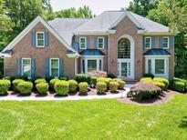 Beautiful brick home featuring manicured landscaping, blue shutters, and a grand two-story entrance at 225 Midenhall Way, Cary, NC 27513
