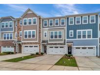 Charming townhouse exteriors boast a mix of stone, siding, and contrasting trim at 2299 Bay Minette Sta # 537, Apex, NC 27502