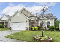Charming home with stone accents, a two-car garage, and well-maintained landscaping at 2410 Kinglass Dr, Fuquay Varina, NC 27526