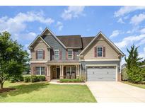 Charming two-story home featuring a manicured lawn, attached garage, and inviting front porch at 2507 Belvinwood Dr, Fuquay Varina, NC 27526