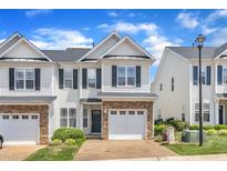 Charming townhome featuring stone accents, a one-car garage, and lush landscaping at 2513 Asher View Ct, Raleigh, NC 27606